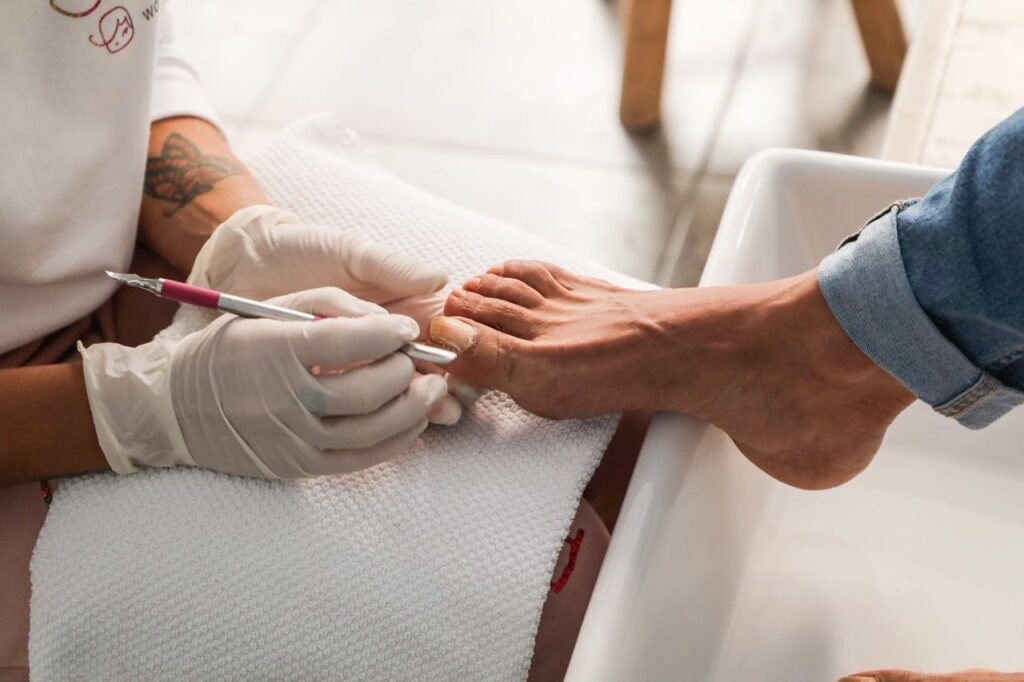 Pedicure session showing gloved hands performing nail care on foot.